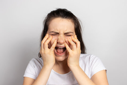 A woman's face hurts. Trigeminal neuralgia, neuritis and nerve inflammation, severe pain in the jaw and sinuses in sinusitis.