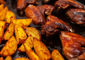 Roasted potatoes and chicken wings in soy sauce cooked in the oven