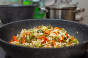 rice with fried vegetables in a pan, home cooking