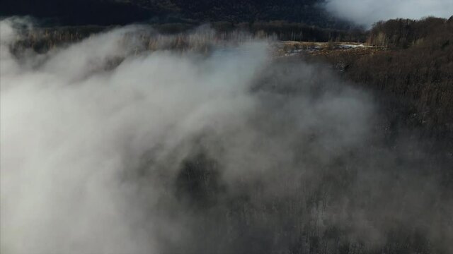 Amazing inspirational epic drone footage of mountain peak and clouds on winter day. Inspiring and mesmerizing calm tranquil shot of flying. Outdoors lifestyle for healthy and fresh air. 