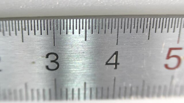 Stainless steel millimeter ruler on a white background.