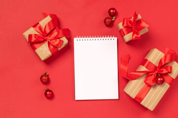 Christmas gifts boxes toys blank notepad red background Festive New Year concept