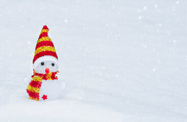 snowman in a red hat and scarf, in the snow in winter