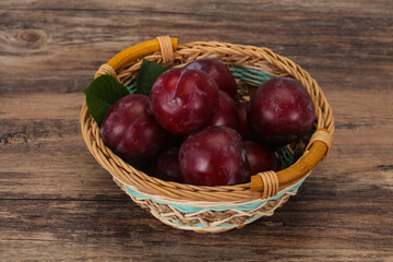 Plum heap in the wooden basket