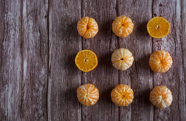 Nine orange fresh tandarines on brown wooden background