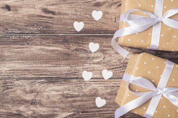 Happy Saint valentines day concept. Above view photo of two wrapped giftboxes with white hearts on wood background