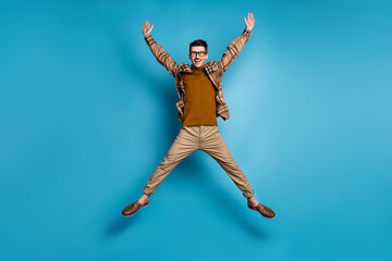 Fototapeta na wymiar Full size photo of young happy crazy smiling excited positive cheerful man jumpin star pose isolated on blue color background