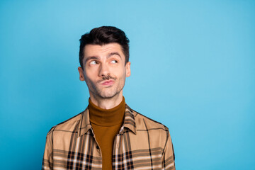 Portrait of young handsome thoughtful minded serious man thinking look copyspace isolated on blue color background