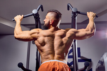 Handsome male bodybuilder in gym. Big strong man during training in the gym. Guy with big muscles who is an athlete, trainer or instructor