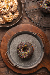 Chocolate frosted donut with colorful festive sprinkles kept in rustic iron plate