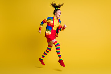 Full length profile side photo of excited girl jump run wear rainbow skirt long socks isolated shine color background