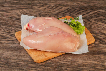 Raw chicken breast over board