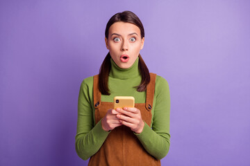 Portrait of lovely amazed girl using device browsing post media pout lips isolated over vibrant violet color background