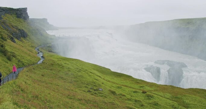 Gullfoss waterfall and silhouette of tourist standing on view platform. Icelandic panoramic landscape view