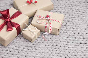 Gift boxes from kafta paper and ribbons on wooden background. Christmas and New Year presents. 
Birthday greetings and gifts.