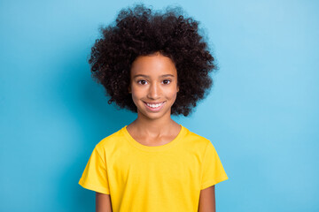 Photo of happy cute lovely dark skin little girl wear yellow t-shirt isolated on blue color background