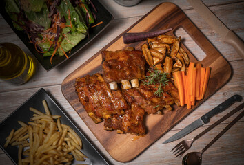 Delicious Pork Spare Ribs Barbecue seasoned with a spicy basting sauce, Grilled sliced barbecue pork ribs on wooden plate.