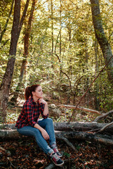 traveler hipster woman standing alone in autumn woods .