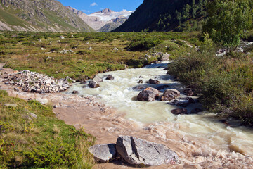 The confluence of two rivers in a mountainous area. Dirty and clean water. Beautiful mountain landscape.