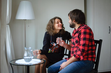 Handsome bearded man dressed in lambersexual style clothes is hugging her young woman in black warm dressed during celebration St. Valentine Day