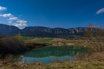 Fototapeta na wymiar reflection from long rocky mountain range in a pond and landscape in the spring