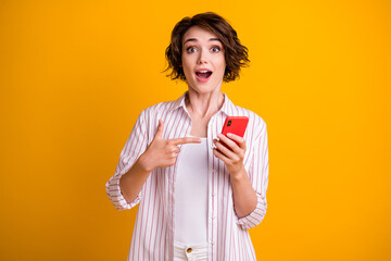 Obraz premium Photo of surprised girl use smartphone impressed social media discounts point finger recommend suggest select ads promo wear stylish trendy clothes isolated bright shine color background