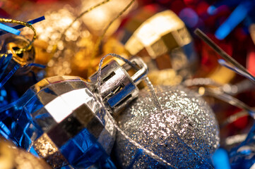 Beautiful glass balls and colored tinsel elements of Christmas tree decoration. New year and Christmas are your favorite holidays. Close-up, selective focus.