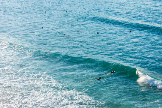 unrecognizable surfers in the water at Langre beach in Cantabria (Spain)