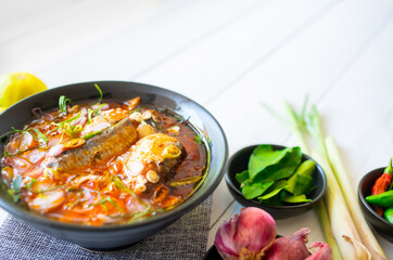 Delicious salad canned fish with vegetables of herbs, lemon, lemongrass, kaffir lime leaves, red Shallot, pepper on A bowl.  Thai food top view copy space for your text