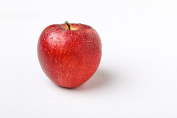 Water drop on fresh red apple on white background