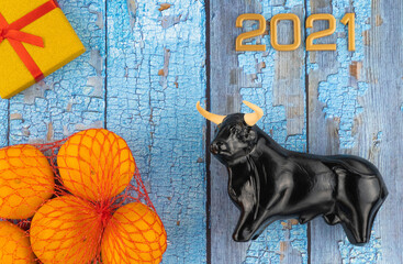 Christmas bull and numbers 2021 on a wooden background. ox, a symbol of the new year according to...