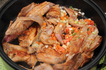 Rabbit fried in a pan with carrot and onion