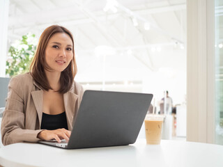 Fototapeta premium ฺBusinesswoman female manager supervisor company office look at camera work computer notebook pad tablet near coffee cup morning for conference meeting online digital marketing technology customer 