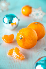 orange tangerines and Christmas tree decorations on a wooden table. wooden snowflakes and Christmas balls on the table. still life with fruits and decorations