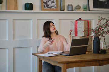 Pretty young lady sitting at desk and typing on laptop with present boxes icons. box receive good online shop purchase at home, post mail shipping delivery concept. woking from home office