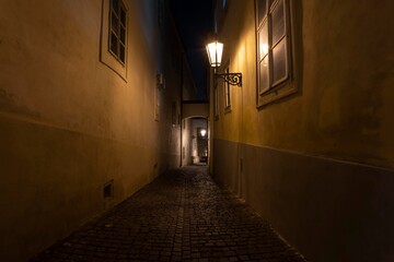 .street lights and pedestrian sidewalk with cobblestones in the center of Prague at night
