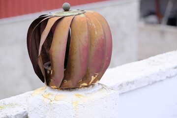 Old and faded rotary chimney aspirator on the roof. Red and corrosive reminings on it.