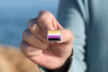 person showing a non-binary pride flag