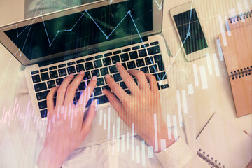 Double exposure of woman hands working on computer and forex chart hologram drawing. Top View....