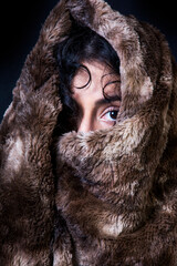 Beautiful woman  with a fur blanket on black background