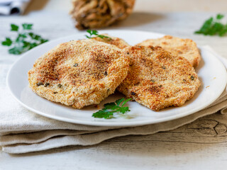 Celeriac cutlet on a white plate. Vegan food