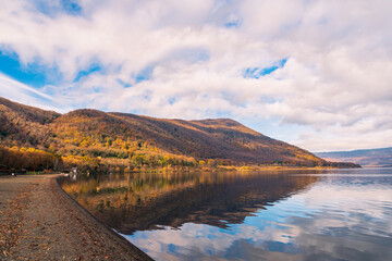 Dark sand lake beach surrounded by hills in Italy
