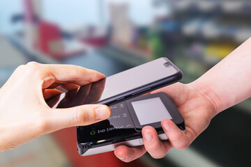 Pos terminals and smartphone. In the background is a supermarket checkout. Banking equipment. Acquiring. Acceptance of bank credit cards. Contactless payment...