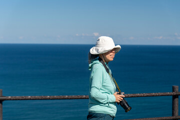 Obraz premium 北海道 礼文島 トド島展望台で撮影する女性カメラマン 