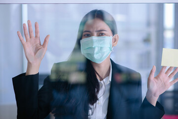 asian lady wear surgical mask upset behind the window