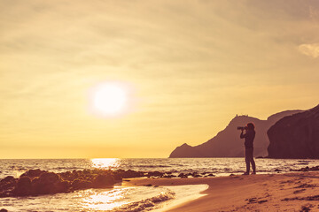 Fototapeta na wymiar Woman with camera on Monsul beach, Spain
