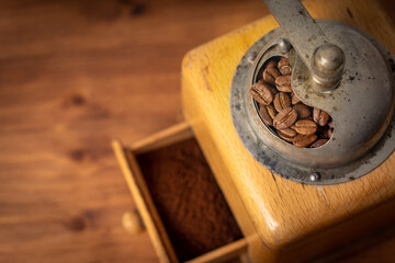 Vintage classic antique italy german manual coffee grinder with hand for organic roasted espresso fresh bean grind to aroma powder in retro old wooden cafe shop with rustic homemade cafe barista style