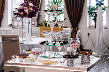 Sweet table. A plates of cakes and muffins. Table with sweets, candy, buffet. Dessert table for a party goodies. Close up. party reception, decorated in restaurant. candy bar