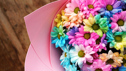 Close up blossom rainbow flowers bright bouquet on wooden background