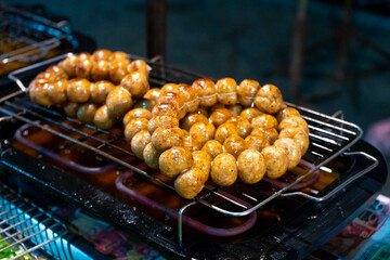 Meatballs are fried on an open-air stove at a street food market in Asia